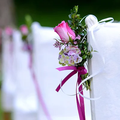 Blumenschmuck an weiß bezogenen Stühlen