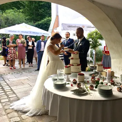 Brautpaar schneidet die Hochzeitstorte im Torbogen