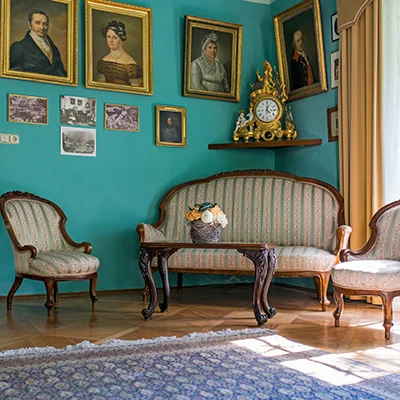 Salon im Schloss mit Familienporträts und historischen Möbeln